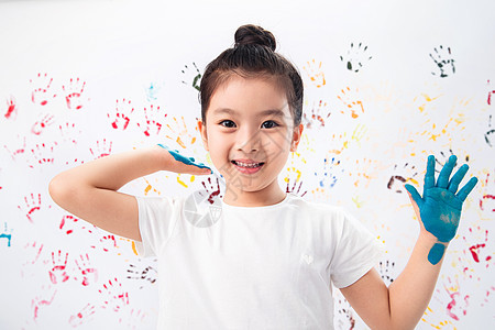 指画墙壁涂料手上涂满颜料的小女孩图片