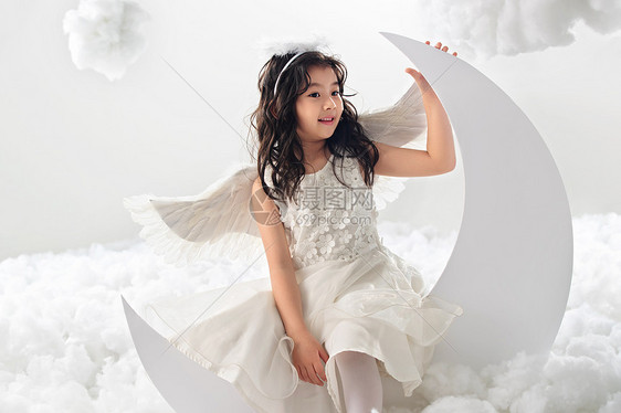 可爱的裙子微笑坐在月亮上的快乐小天使图片