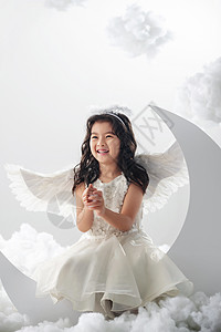仅一个女孩裙子翅膀坐在月亮上的快乐小天使图片