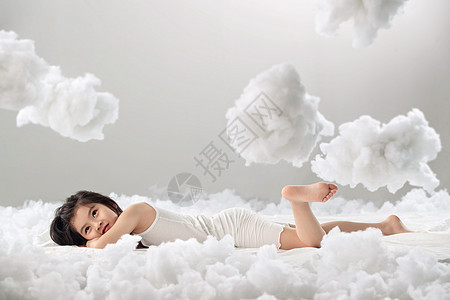 欢乐乐趣表现积极可爱的小女孩躺在云朵上图片
