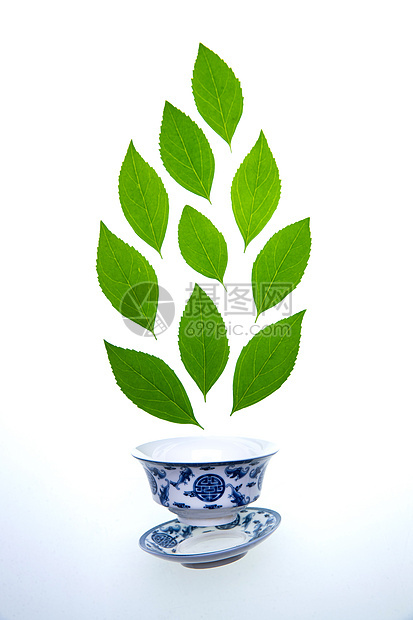 绿色的茶叶和瓷器茶杯图片