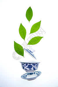 绿色的茶叶和青花瓷茶杯图片