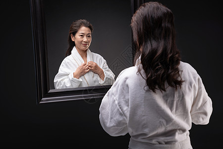中国魅力城市优美干净享乐照镜子的优雅中年女人背景