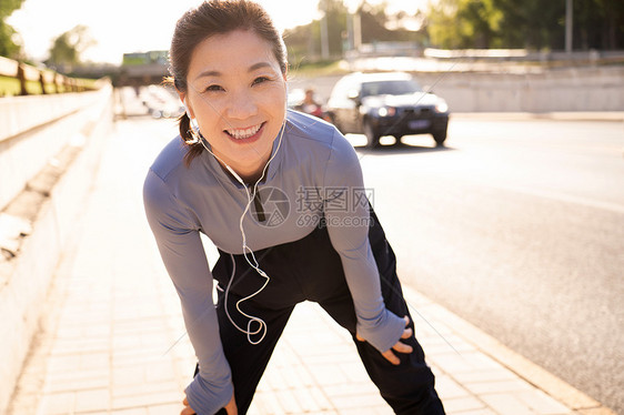 中年人中年女子在马路旁健身图片