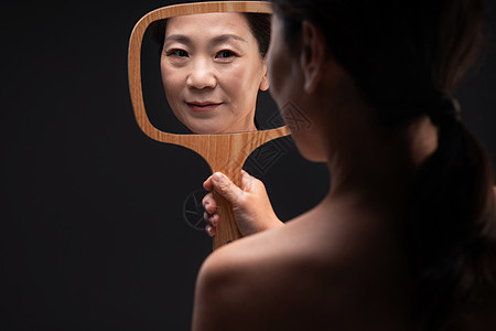 幸福照镜子中老年人拿着镜子照的中年女人图片素材