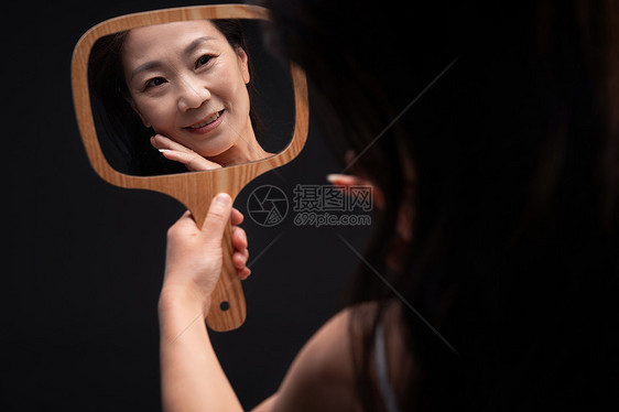 拿着镜子照的中年女人图片
