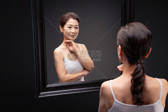优雅的中年女欣赏镜子中的自己图片