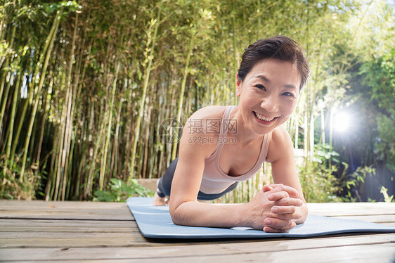 户外中老年女士趴着练瑜伽图片