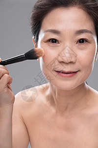 优雅拿着化妆刷的中年女人图片