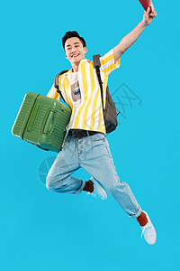 20岁到25岁青春享乐抱着行李箱去旅行的年轻男人图片