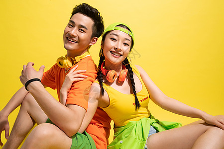 情侣背靠背坐着陪伴25岁到29岁亚洲背靠背坐着的时尚青年情侣背景