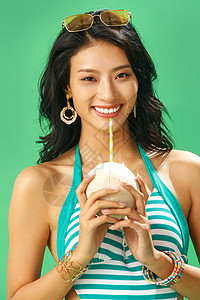 户内色彩鲜艳凉爽喝椰子汁的泳装美女肖像图片