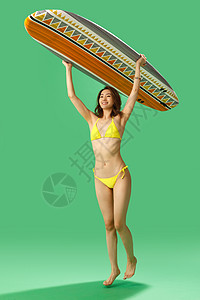 身材穿比基尼的美女举着冲浪板图片
