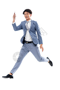 男人户内互联网拿着手机奔跑跳跃的商务男士图片