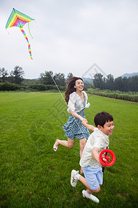 快乐的母子在草地上放风筝图片