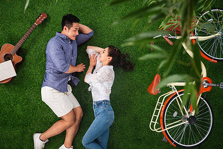 正上方视角相伴亲情幸福的青年伴侣在草地上享受甜蜜时光图片