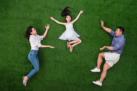 青年女人活力奔跑草地上做游戏的一家三口图片