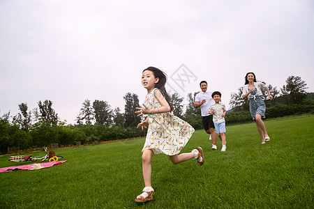 快乐的一家四口在草地上奔跑图片