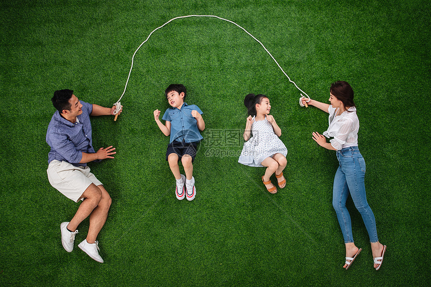 东亚保护6到7岁快乐的一家四口在草地上跳绳图片
