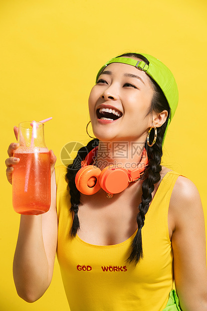 耳机黄色背景青年文化喝饮料的青年女人图片