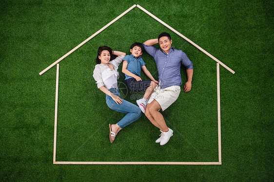 模拟东方人幻想快乐的一家三口躺在草地上的房子轮廓里图片