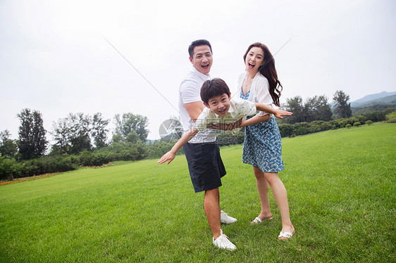 张着嘴山亚洲草地上幸福的三口之家图片