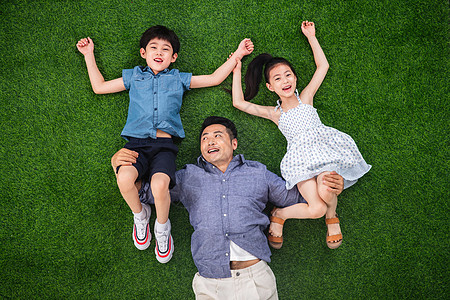 在草地上父亲托举儿子和女儿高清图片