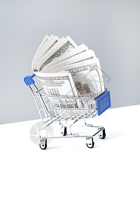 垂直构图棚拍现代购物车和美国百元钞票图片