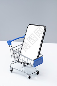 灰色背景移动支付智能手机购物车和空白屏幕的手机背景图片
