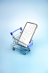 购买互联网棚拍购物车和空白屏幕的手机背景图片