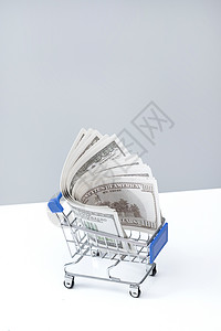 垂直构图白昼财富购物车和美国百元钞票背景图片
