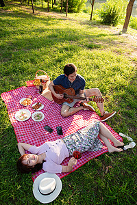 风景摄影女朋友享乐摄影在公园里弹吉他的幸福情侣背景