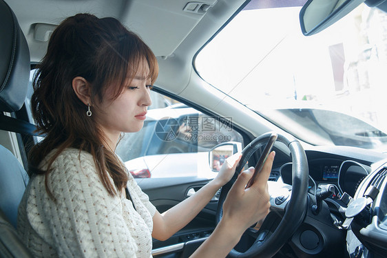 烦躁户外侧面视角开车的青年女人图片