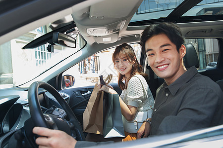 自信都市风光两个人坐在汽车里的快乐情侣图片