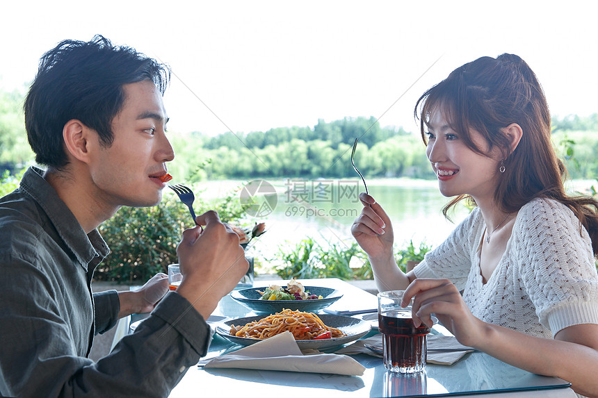 休闲吃面对面快乐情侣在餐厅里用餐