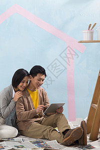 活力倚靠平板电脑年轻夫妇装修房子图片