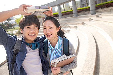 休闲挨着成年学生快乐的青年大学生情侣图片