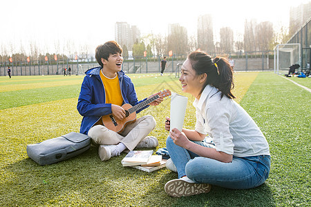 青年大学生在校园里弹奏吉他图片