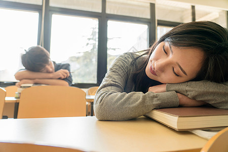 成年人努力精疲力尽疲劳的大学生在教室里睡觉图片