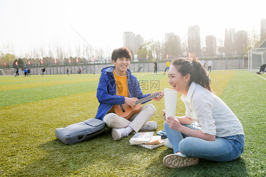 青年大学生在校园里弹奏吉他图片