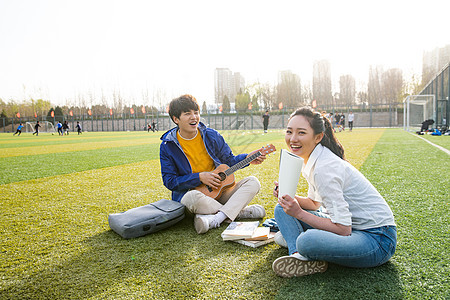 青年大学生在校园里弹奏吉他图片