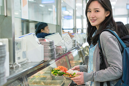 成年人20到24岁快乐大学生在食堂里用餐图片