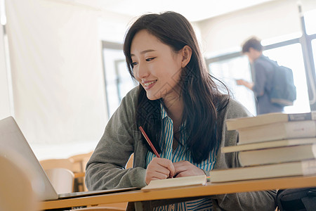 活力白昼青年女人大学生在教室里学习图片