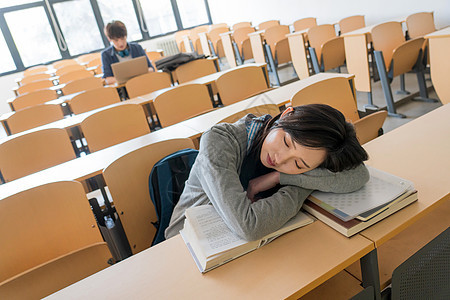 青年女人不看镜头男人疲劳的大学生在教室里睡觉图片