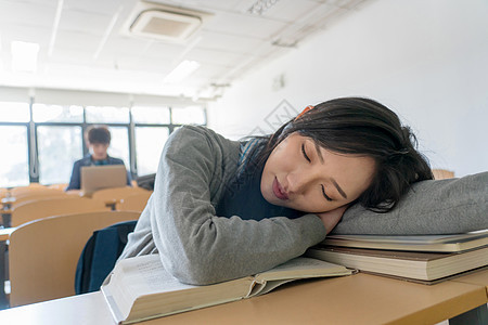 友谊成人教育休闲装疲劳的大学生在教室里睡觉图片