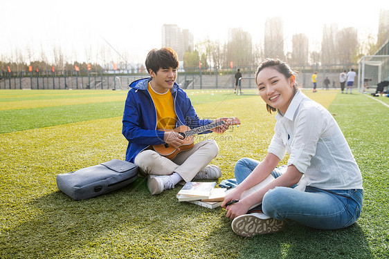 20到24岁高等教育教科书青年大学生在校园里弹奏吉他图片