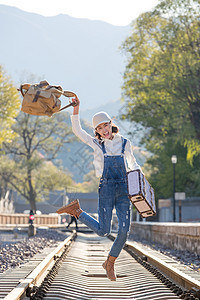 青年女人在铁轨上跳跃图片