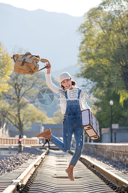 青年女人在铁轨上跳跃图片