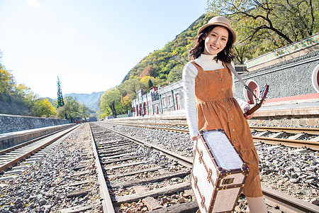 青年女人在铁轨上行走图片