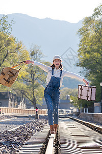 青年女人在铁轨上行走图片